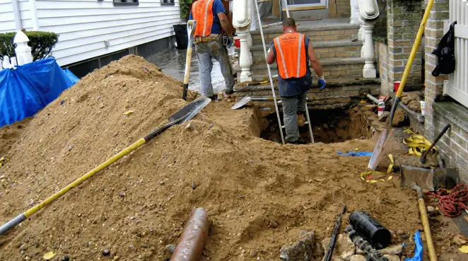 Contractors performing foundation protection and exterior drainage excavation near residential home steps in Reno, NV